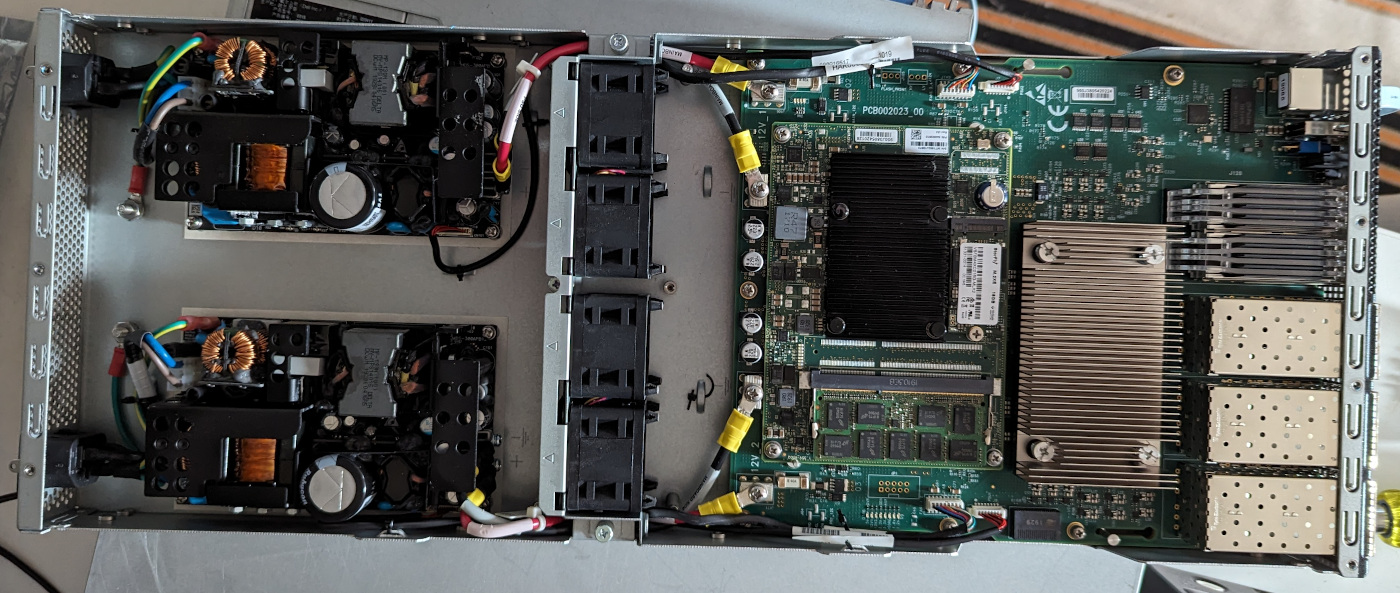 The insides of a switch, there are 4 boards, 2 back PSUs, 1 main switch board, and a riser board containing the control plane